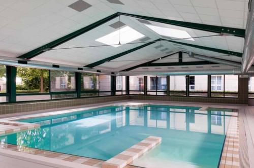 une grande piscine avec une grande fenêtre dans l'établissement Appartement proche Disneyland, Val d'Europe, Paris #1, à Serris