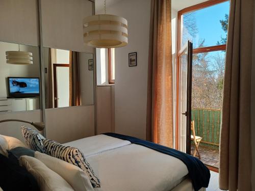 um quarto com um espelho, uma cama e uma janela em Apartment Antiope em Zagreb