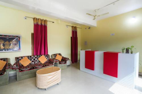 a living room with red curtains and couches at OYO Hotel Shree Balajee 1 in Puri