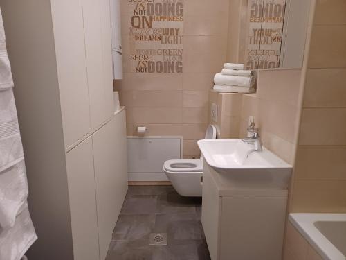 a bathroom with a white toilet and a sink at Apartment Antiope in Zagreb