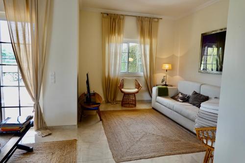 un soggiorno con divano e sedia di Villa Formosa Golf a Quinta do Lago