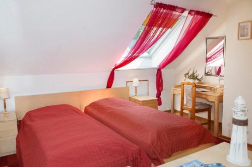 a bedroom with a red bed and a desk at Privatvermietung Giese in Kiel