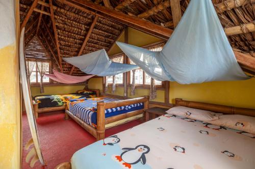 a bedroom with two beds and a hammock at La Casa Mompiche in Mompiche