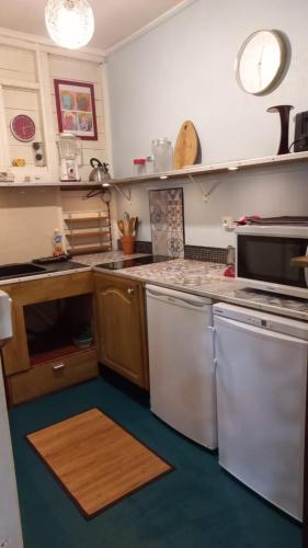 a kitchen with a sink and a stove and a microwave at Cap Martinique in Sainte-Anne