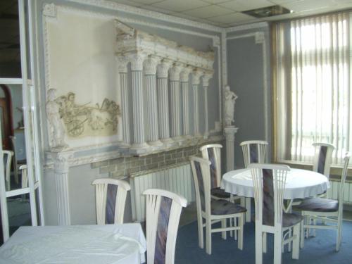 a dining room with tables and chairs and a radiator at Family Hotel George in Svilengrad