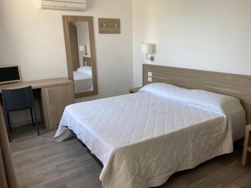 een slaapkamer met een bed, een bureau en een spiegel bij Hotel Nova Domus Aurelia in Rome