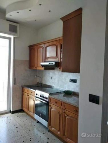 a kitchen with wooden cabinets and a stove at Ad Un Passo Dal Mare in Savona