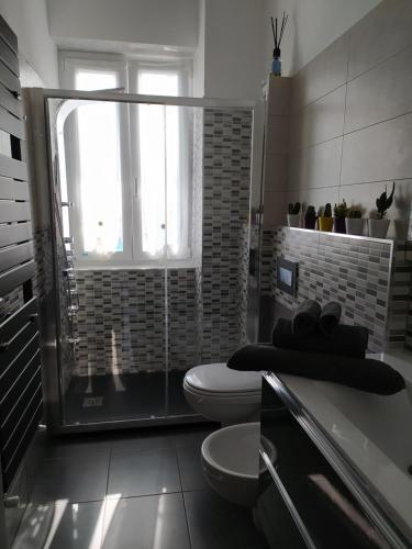 a bathroom with a shower and a toilet and a window at Ad Un Passo Dal Mare in Savona