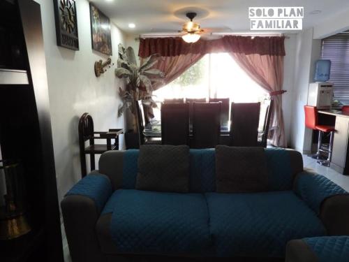 a living room with a blue couch in front of a window at Bonita Casa en Condominio con Alberca y Acceso al Lago in Tequesquitengo