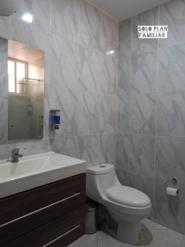a bathroom with a sink and a toilet and a mirror at Bonita Casa en Condominio con Alberca y Acceso al Lago in Tequesquitengo