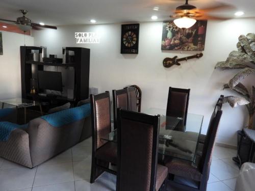 a dining room with a glass table and chairs at Bonita Casa en Condominio con Alberca y Acceso al Lago in Tequesquitengo