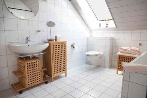 La salle de bains blanche est pourvue d'un lavabo et de toilettes. dans l'établissement Privatvermietung Giese, à Kiel