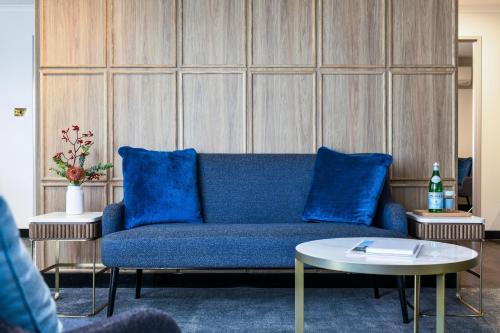 a living room with a blue couch and a table at Powerhouse Hotel Tamworth by Rydges in Tamworth