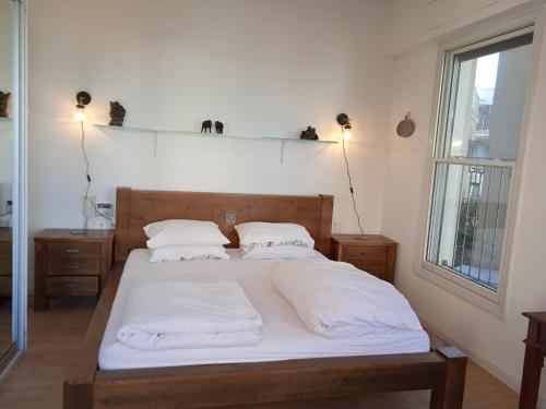 a bedroom with a bed with white sheets and pillows at Jaffa sea front, luxury Duplex, Port & Old City 2m walk in Tel Aviv
