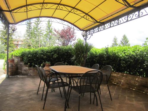a table and chairs under a yellow umbrella on a patio at La Strada Di Francesco D'Assisi in Bastia Umbra