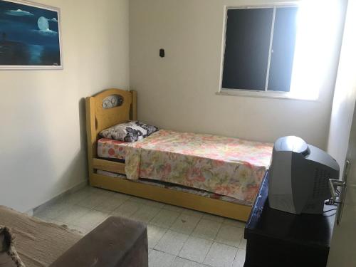 Mar Azul Condomínio في أراكاجو: غرفة نوم صغيرة بها سرير وتلفزيون