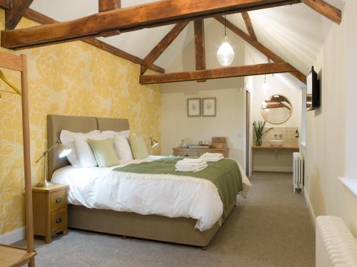 a bedroom with a large bed in a room at Coach House Ratho Park Steading in Ratho