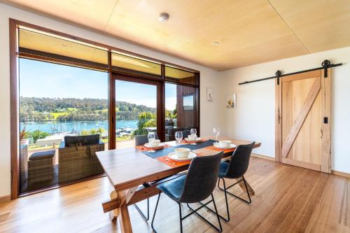 Un comedor con mesa y sillas y una gran ventana. en Little Oyster Bayview, en Kettering