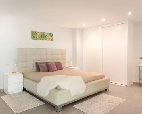 BenijófarにあるLily’s Casaの白い部屋に大型ベッド1台が備わるベッドルーム1室が備わります。