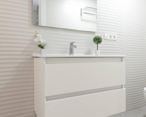 a white bathroom with a sink and a mirror at Lily’s Casa in Benijófar