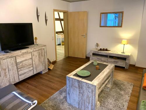 a living room with a flat screen tv and a table at Villa Ammonit in Pottenstein