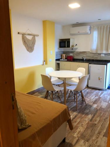 a room with a bed and a table and chairs at Los Naranjos Apart Hotel in Villa Carlos Paz