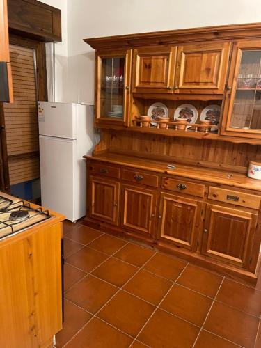 una cucina con armadi in legno e frigorifero bianco di IL GECO DI MONTAGNA a Castel di Sangro
