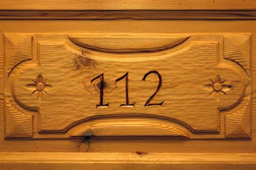 a wooden sign on a wooden wall with the number on it at Les Combes in La Salle