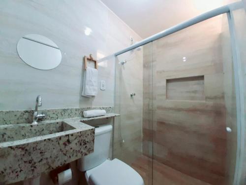 uma casa de banho com um chuveiro, um WC e um lavatório. em Apartamento à beira mar da praia do francês na Praia do Francês