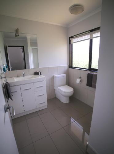 a white bathroom with a toilet and a sink at Palm City Motor Inn in Napier