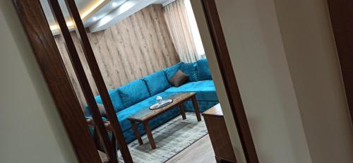 a blue couch in a living room with a table at Jasmin President Kop in Kopaonik