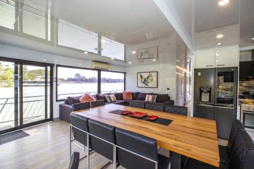 a kitchen and living room with a wooden table at All Seasons Houseboats in Mildura