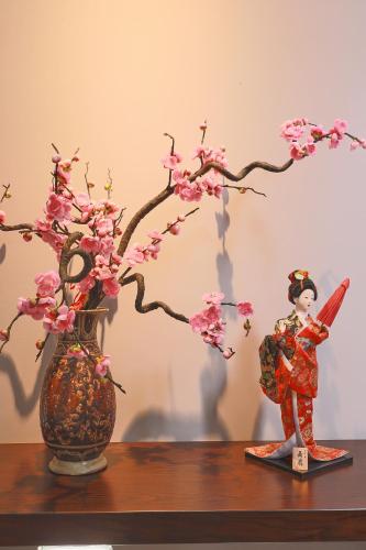 two dolls and a vase with flowers on a table at CHERRY BOUTIQUE HOTEL in Ho Chi Minh City