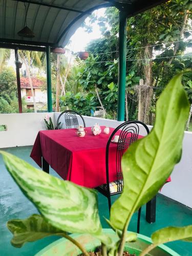 una mesa roja con sillas y un mantel rojo en Surewo Apartment, en Bentota