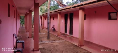 a row of pink houses with a bench in the courtyard at Isuruma Rest in Kataragama