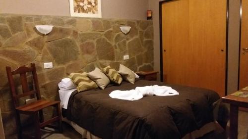 Una cama con dos toallas encima en Kawo Apart Hotel, en Puerto Santa Cruz