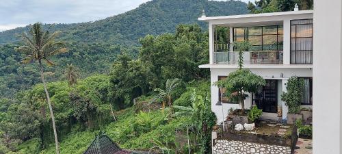 a white house with a view of a mountain at Villa Aryaguna in Senggigi 