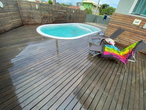 terraza con mesa y silla junto a la piscina en Siri Mariscal. Casa com Piscina, en Bombinhas