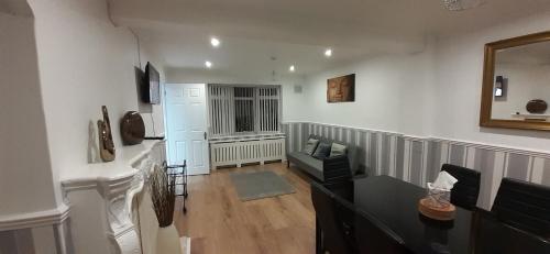 a living room with a couch and a mirror at Ladbury House in Walsall near M6, Walsall Uni and Hospital, with free parking and easy access to Birmingham city centre and West Bromwich, only 20 mins to NEC and Birmingham airport, 15 mins to Villa Park, Great for contractors! in Bescot