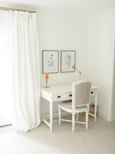 a white desk with a chair next to a window at Fairville Inn in Chadds Ford
