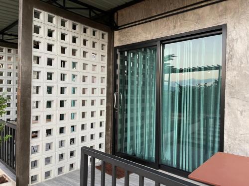 a balcony with sliding glass doors on a building at Por Sampao Camp&Resort in Ban Pha Saeng Lang