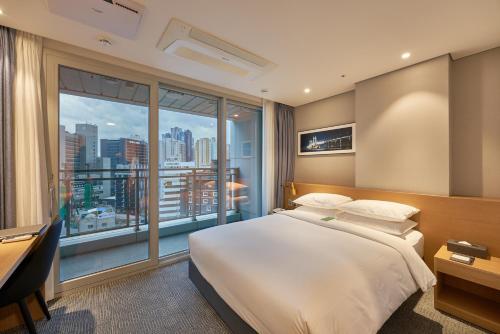 a hotel room with a bed and a large window at Lavi De Atlan Hotel 2 in Busan