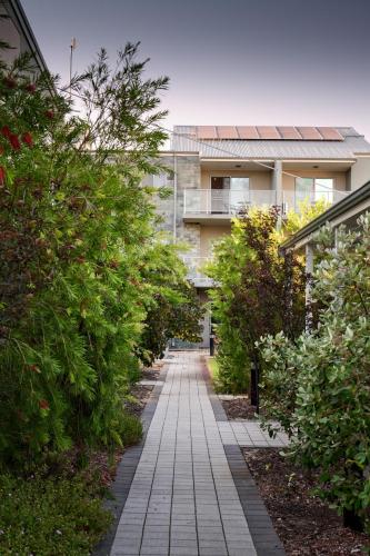 a walkway in front of a building with plants at Airport Apartments by Vetroblu in Perth