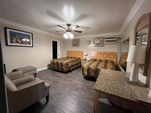 a hotel room with two beds and a couch at Flamingo Motel Oxnard in Oxnard