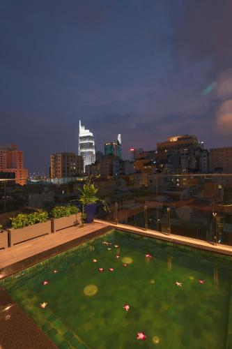 a swimming pool with a city skyline in the background at CHERRY BOUTIQUE HOTEL in Ho Chi Minh City