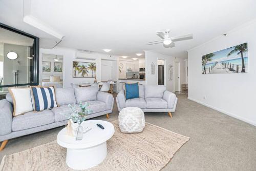 a living room with two couches and a table at Broadbeach Victoria Square in Gold Coast