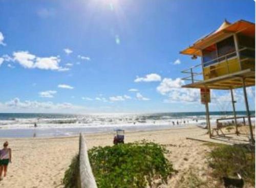 a beach with a building and people on the beach at Broadbeach Victoria Square in Gold Coast