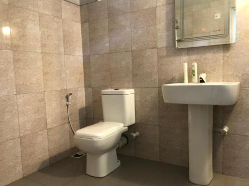a bathroom with a toilet and a sink at Eco Willow - Kathaluwa in Atadahewatugoda