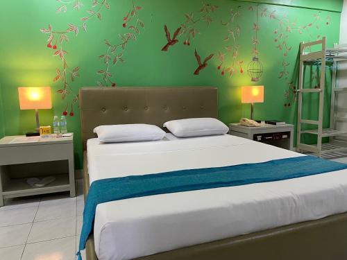 a bedroom with a large bed with green walls at Riverview Resort and Conference Center in Calamba