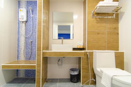 La salle de bains est pourvue de toilettes et d'un lavabo. dans l'établissement Bleu Marine Sattahip Hotel, à Ban Nong Srah